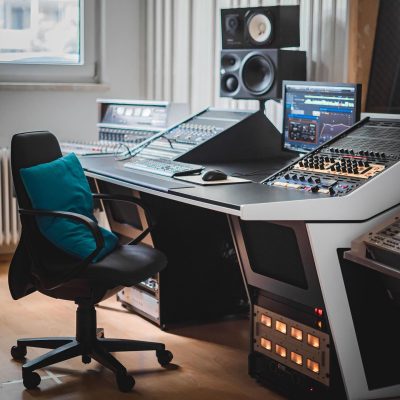 Side view of Green Lobster Studios with a white V3 Acoustic 56RU Desk customised to a 25-degree angle.