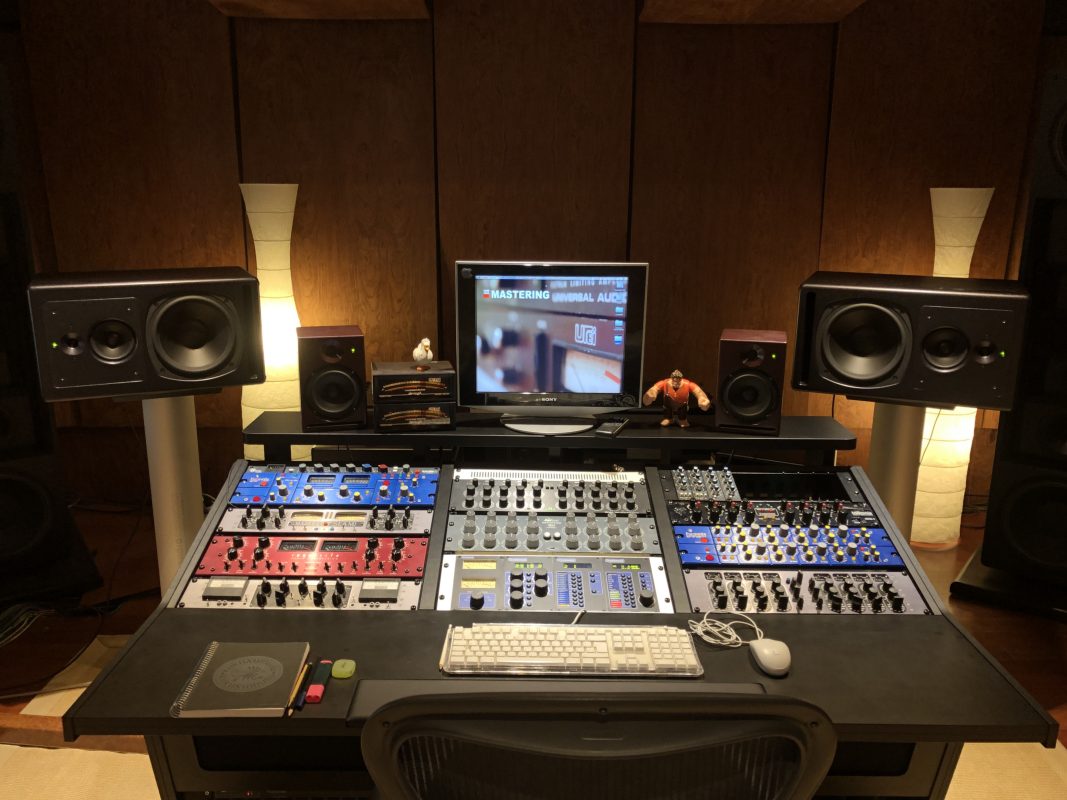 General view of PKO Studios with a black V3 Acoustic 78RU Desk, an upper shelf and integrated studio equipment.