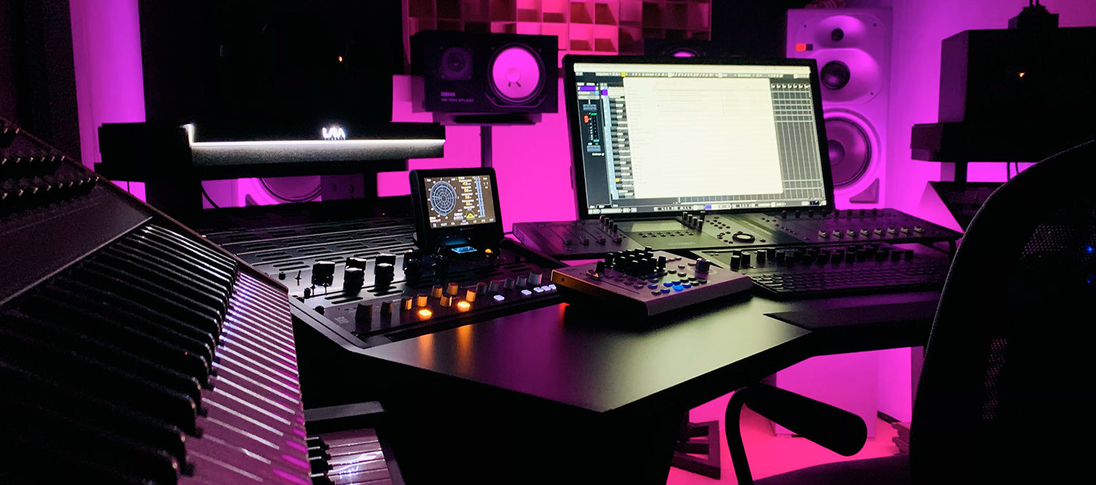 Vista frontal del estudio de Typhoon Producer con un Escritorio V3 Acoustic 56RU-A negro, equipos de producción y monitores.